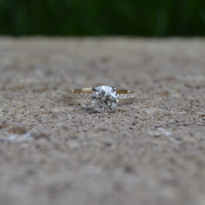 Custom Designed two tone (white and yellow gold) round diamond prong set engagement ring with shared prong round diamonds in the shank