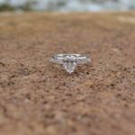 Custom designed Pear shaped diamond engagement ring with channel set round diamonds in the shank in white gold