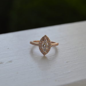 Custom designed marquise diamond halo engagement ring and diamond shank with shared prongs in rose gold