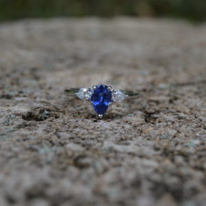 Custom designed lady's ring with pear shaped sapphire and pear shaped diamonds in white gold