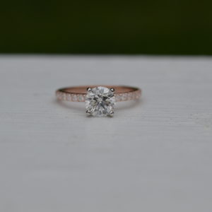 Custom Round diamond engagement ring with round diamonds set with shared prongs in shank in rose gold
