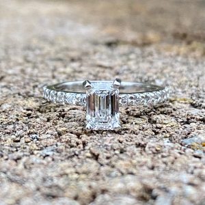 Custom Designed Emerald Cut Diamond Solitaire with Round Diamonds in Shared Prong Shank